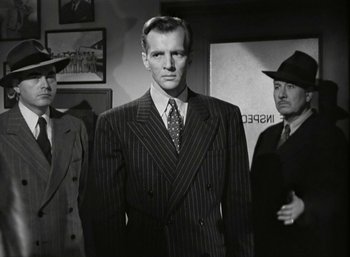 Movie still from “Mildred Pierce” (1945), directed by Michael Curtiz – A man in a striped suit standing next to two other men; Medium shot, Low angle