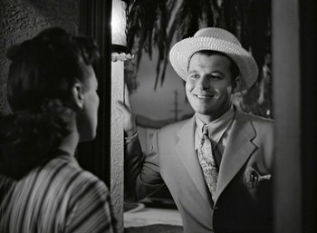 Movie still from “Mildred Pierce” (1945), directed by Michael Curtiz – A black and white photo of a man wearing a hat; Medium shot, Over the shoulder angle