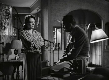 Movie still from “Mildred Pierce” (1945), directed by Michael Curtiz – A man and a woman standing next to each other in front of a railing; Medium shot, High angle