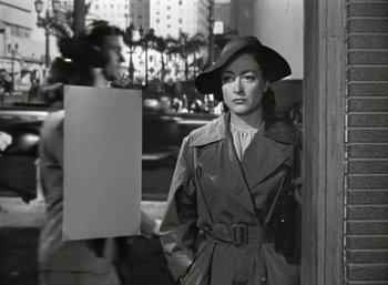Movie still from “Mildred Pierce” (1945), directed by Michael Curtiz – A black and white photo of a woman wearing a hat; Medium shot, Over the shoulder angle