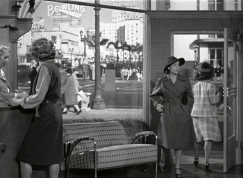 Movie still from “Mildred Pierce” (1945), directed by Michael Curtiz – An old black and white photo of a woman wearing a hat; Wide shot, Low angle
