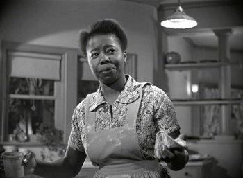 Movie still from “Mildred Pierce” (1945), directed by Michael Curtiz – An older black woman holding a piece of food; Close Up shot, Low angle