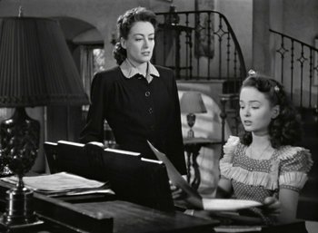 Movie still from “Mildred Pierce” (1945), directed by Michael Curtiz – A woman standing next to a young girl in front of a piano; Medium shot, High angle