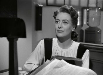Movie still from “Mildred Pierce” (1945), directed by Michael Curtiz – An old black and white photo of a woman sitting at a desk; Close Up shot, Over the shoulder angle