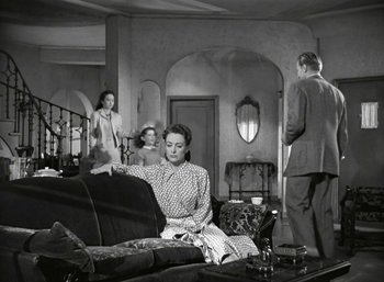 Movie still from “Mildred Pierce” (1945), directed by Michael Curtiz – A group of people sitting on a couch in a living room; Wide shot, High angle