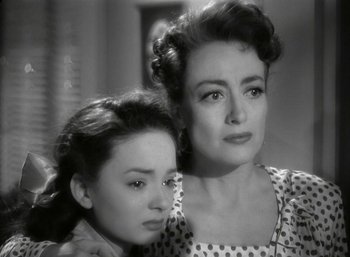 Movie still from “Mildred Pierce” (1945), directed by Michael Curtiz – A woman standing next to a woman with her arm around her shoulder; Close Up shot, High angle