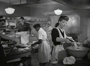 Movie still from “Mildred Pierce” (1945), directed by Michael Curtiz – A group of people in a kitchen preparing food; Medium shot, Low angle