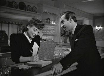 Movie still from “Mildred Pierce” (1945), directed by Michael Curtiz – A man and a woman sitting at a counter; Medium shot, High angle