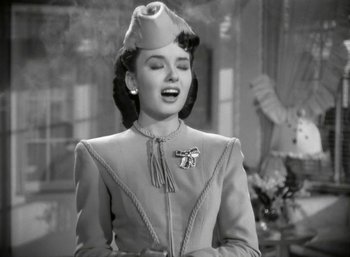 Movie still from “Mildred Pierce” (1945), directed by Michael Curtiz – A woman wearing a hat and a dress; Close Up shot, Low angle