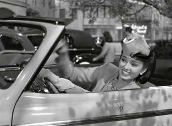 Movie still from “Mildred Pierce” (1945), directed by Michael Curtiz – A woman sitting in the driver's seat of a car; Medium shot, High angle