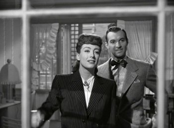 Movie still from “Mildred Pierce” (1945), directed by Michael Curtiz – A man and a woman standing next to each other; Medium shot, High angle