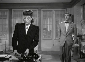 Movie still from “Mildred Pierce” (1945), directed by Michael Curtiz – A man and a woman standing next to each other in a room; Medium shot, High angle