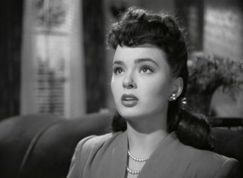 Movie still from “Mildred Pierce” (1945), directed by Michael Curtiz – A black - and - white photo of a woman in a dress; Close Up shot, High angle