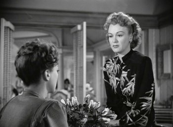 Movie still from “Mildred Pierce” (1945), directed by Michael Curtiz – A woman is talking to a young boy in front of a mirror; Medium shot, Over the shoulder angle