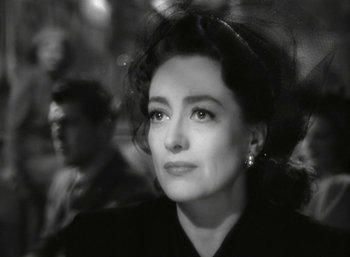 Movie still from “Mildred Pierce” (1945), directed by Michael Curtiz – Black and white photograph of a woman in a black dress; Close Up shot, Over the shoulder angle