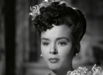 Movie still from “Mildred Pierce” (1945), directed by Michael Curtiz – An old photo of a woman with a flower in her hair; Close Up shot, Over the shoulder angle