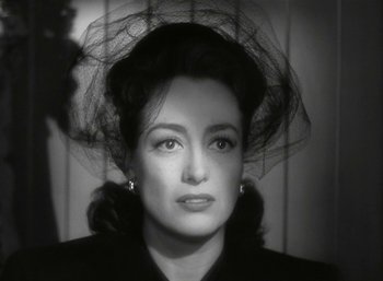 Movie still from “Mildred Pierce” (1945), directed by Michael Curtiz – A black and white photo of a woman with a veil on her head; Close Up shot, Over the shoulder angle