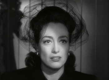 Movie still from “Mildred Pierce” (1945), directed by Michael Curtiz – A black and white photo of a woman with a veil on her head; Close Up shot, Over the shoulder angle