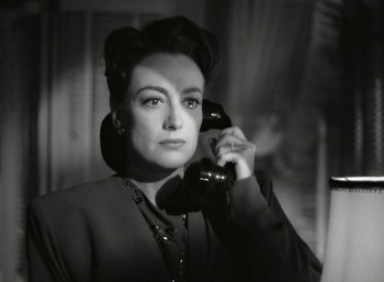 Movie still from “Mildred Pierce” (1945), directed by Michael Curtiz – An old photo of a woman holding a phone up to her ear; Close Up shot, High angle
