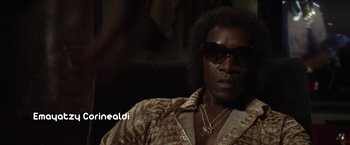 Movie still from “Miles Ahead” (2015), directed by Don Cheadle – A man sitting in a chair wearing sunglasses; Close Up shot, Low angle