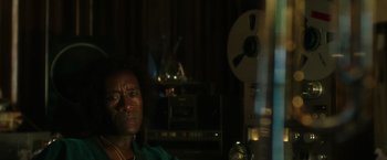 Movie still from “Miles Ahead” (2015), directed by Don Cheadle – A man sitting in front of an old record player; Close Up shot, Over the shoulder angle