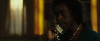 Movie still from “Miles Ahead” (2015), directed by Don Cheadle – A man talking on a phone while sitting down; Close Up shot, Low angle