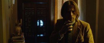 Movie still from “Miles Ahead” (2015), directed by Don Cheadle – A man is smoking a cigarette in the dark; Medium shot, Low angle