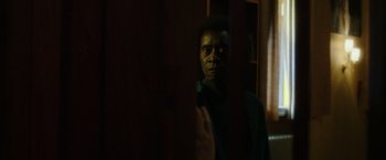 Movie still from “Miles Ahead” (2015), directed by Don Cheadle – A man standing in front of a mirror in the dark; Close Up shot, Over the shoulder angle