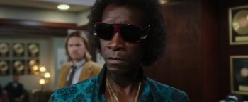 Movie still from “Miles Ahead” (2015), directed by Don Cheadle – A person wearing sunglasses; Close Up shot, Low angle