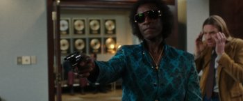 Movie still from “Miles Ahead” (2015), directed by Don Cheadle – A man holding a remote control in his hand; Medium shot, Low angle