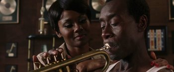 Movie still from “Miles Ahead” (2015), directed by Don Cheadle – A man and a woman are playing a trumpet together; Close Up shot, Over the shoulder angle
