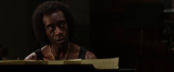 Movie still from “Miles Ahead” (2015), directed by Don Cheadle – A man sitting at a piano in a dark room; Close Up shot, Over the shoulder angle