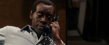 Movie still from “Miles Ahead” (2015), directed by Don Cheadle – A man talking on a phone while wearing a white shirt; Close Up shot, Low angle