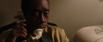 Movie still from “Miles Ahead” (2015), directed by Don Cheadle – A person holding a pipe in his mouth; Close Up shot, High angle