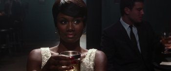 Movie still from “Miles Ahead” (2015), directed by Don Cheadle – A woman holding a glass of wine in her hand; Close Up shot, Over the shoulder angle