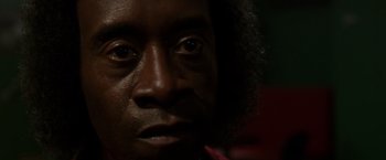 Movie still from “Miles Ahead” (2015), directed by Don Cheadle – A man's face with a red flower in his hand; Extreme Close Up shot, Low angle