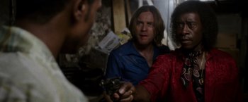 Movie still from “Miles Ahead” (2015), directed by Don Cheadle – A man in a blue shirt is holding a gun; Close Up shot, Over the shoulder angle