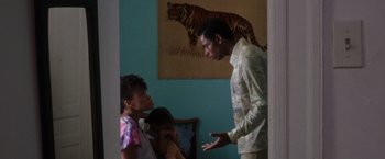 Movie still from “Miles Ahead” (2015), directed by Don Cheadle – A man and two women in front of a painting of a tiger; Medium shot, Over the shoulder angle