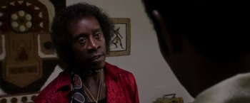 Movie still from “Miles Ahead” (2015), directed by Don Cheadle – A man in a red jacket is talking to a woman; Close Up shot, Low angle