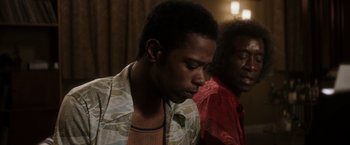 Movie still from “Miles Ahead” (2015), directed by Don Cheadle – A man and a woman sitting next to each other in a room; Close Up shot, Low angle