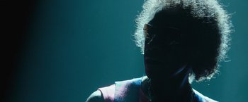 Movie still from “Miles Ahead” (2015), directed by Don Cheadle – A woman wearing glasses is looking into the distance; Close Up shot, Low angle