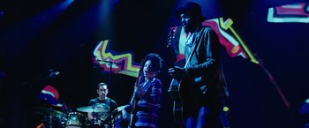 Movie still from “Miles Ahead” (2015), directed by Don Cheadle – A group of people that are on a stage; Medium shot, Low angle