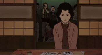 Movie still from “Millennium Actress” (2001), directed by Kô Matsuo – An animated scene of a woman sitting in front of a group of people; Medium shot, Over the shoulder angle