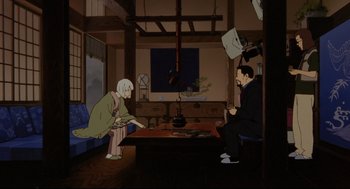 Movie still from “Millennium Actress” (2001), directed by Kô Matsuo – A man and a woman sitting at a table in a room; Wide shot, High angle