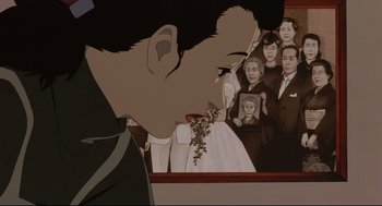 Movie still from “Millennium Actress” (2001), directed by Kô Matsuo – A man holding a bouquet of flowers in front of an image of people; Close Up shot, Low angle