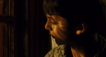 Movie still from “Mimic” (1997), directed by Guillermo del Toro – A young boy is looking into the light; Close Up shot, High angle