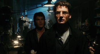 Movie still from “Mimic” (1997), directed by Guillermo del Toro – A man in a black jacket standing next to another man in a black jacket; Close Up shot, Low angle