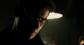 Movie still from “Mimic” (1997), directed by Guillermo del Toro – A person wearing glasses; Close Up shot, Low angle