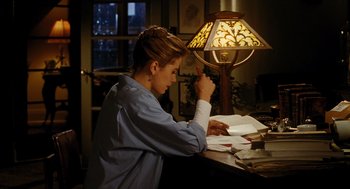 Movie still from “Mimic” (1997), directed by Guillermo del Toro – A woman sitting at a table writing on papers; Medium shot, High angle
