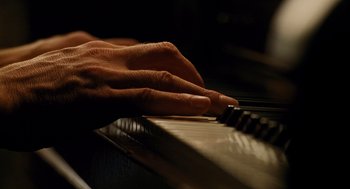 Movie still from “Mimic” (1997), directed by Guillermo del Toro – A person's hands playing a piano; Extreme Close Up shot, Overhead angle